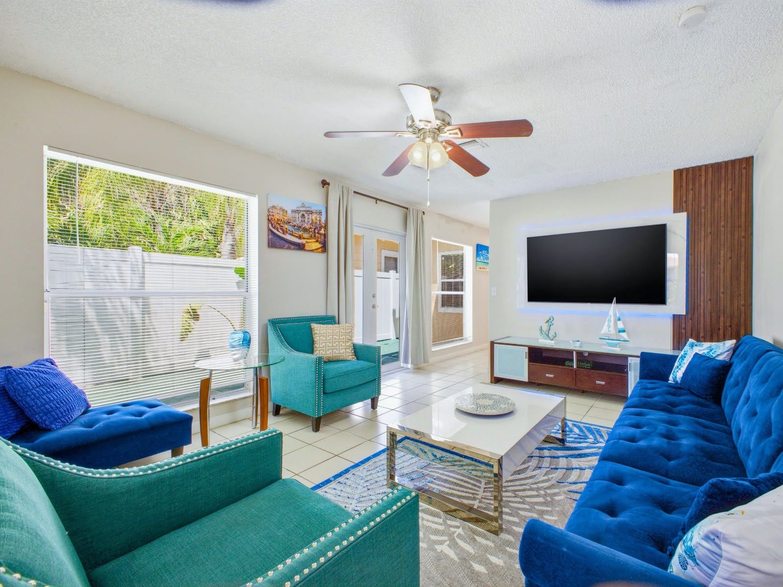Living room with blue velvet sofa and large TV